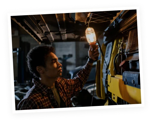 a mechanic holding an industrial light completing services with short lead time